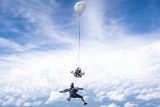 Outside view of a videographer capturing a tandem skydiving student and instructor in freefall